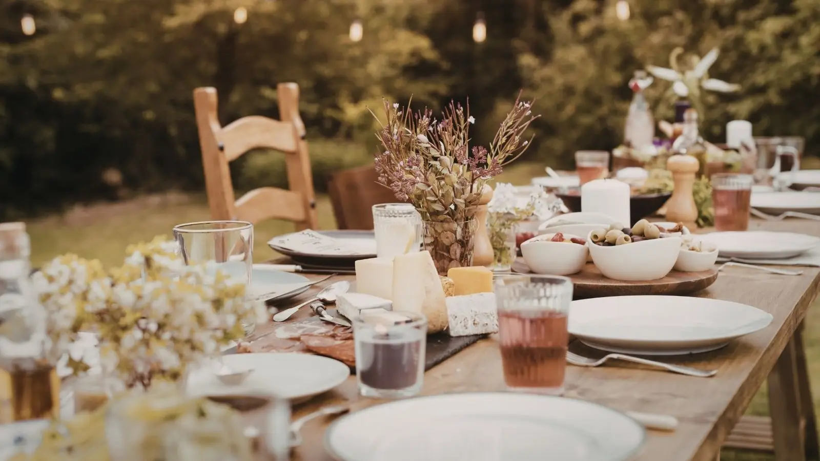 Outdoor rustic dinner table with cheese and flowers